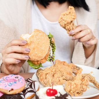 Girl eating a burger and fried chicken
