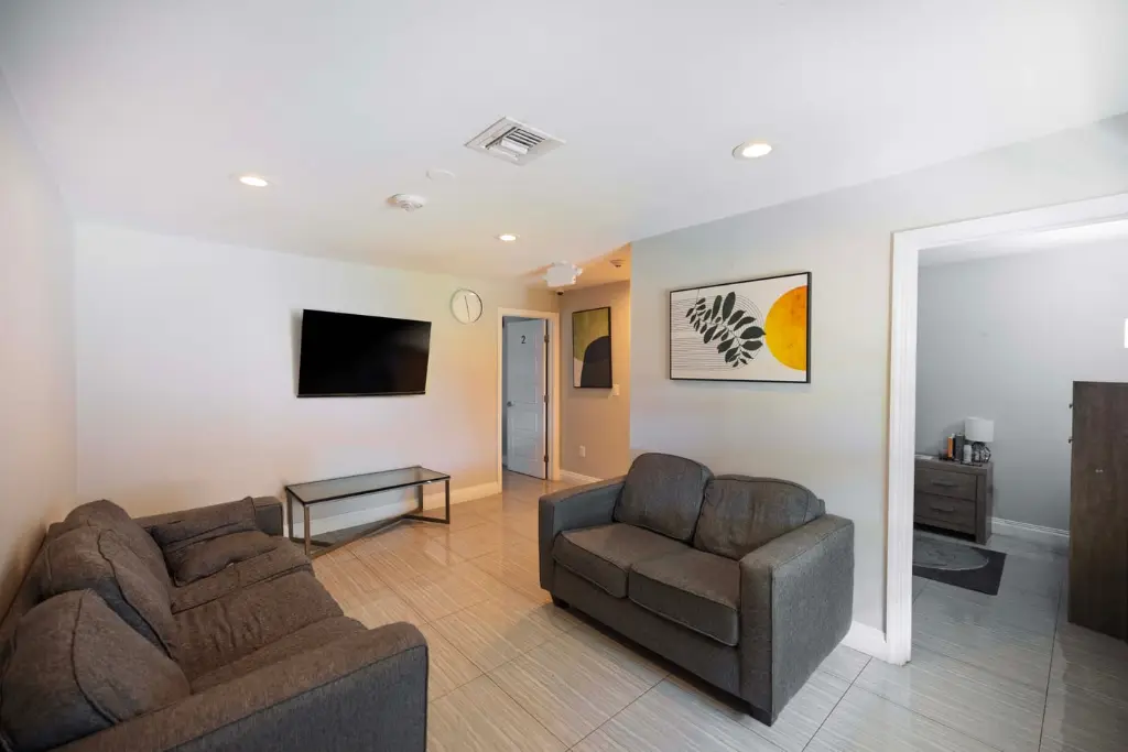 Comfortable client lounge with sofas and TV at Harbor Village addiction treatment center